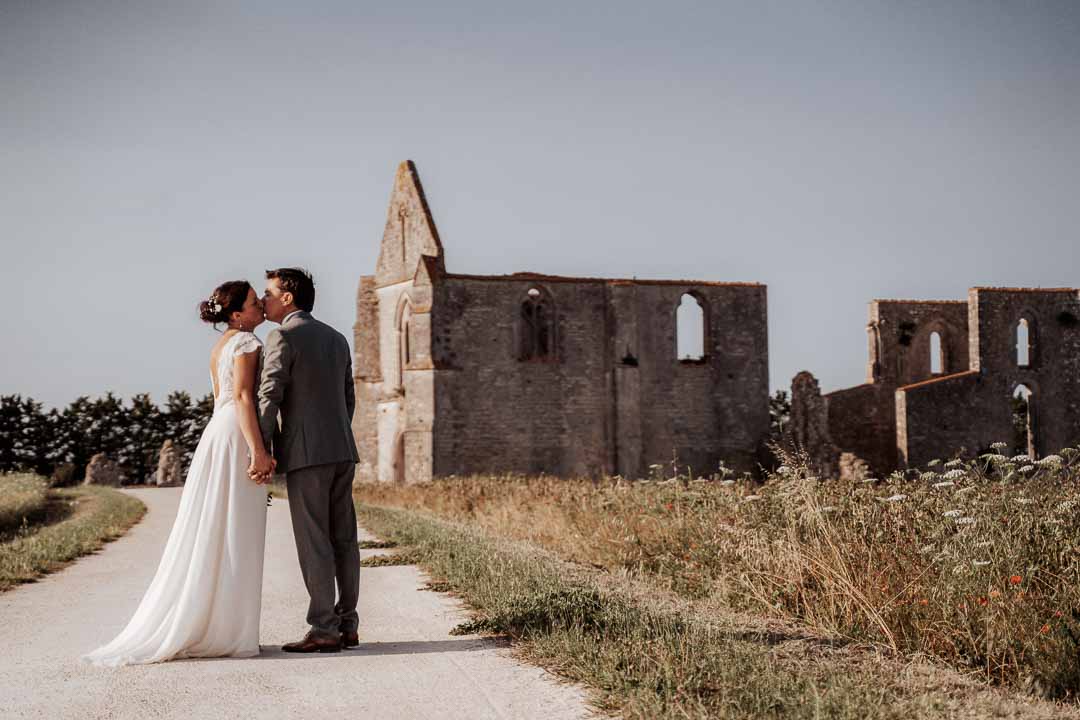 couple marié s'embrassant devant l'abbaye des chateliers à la flotte, ile de ré