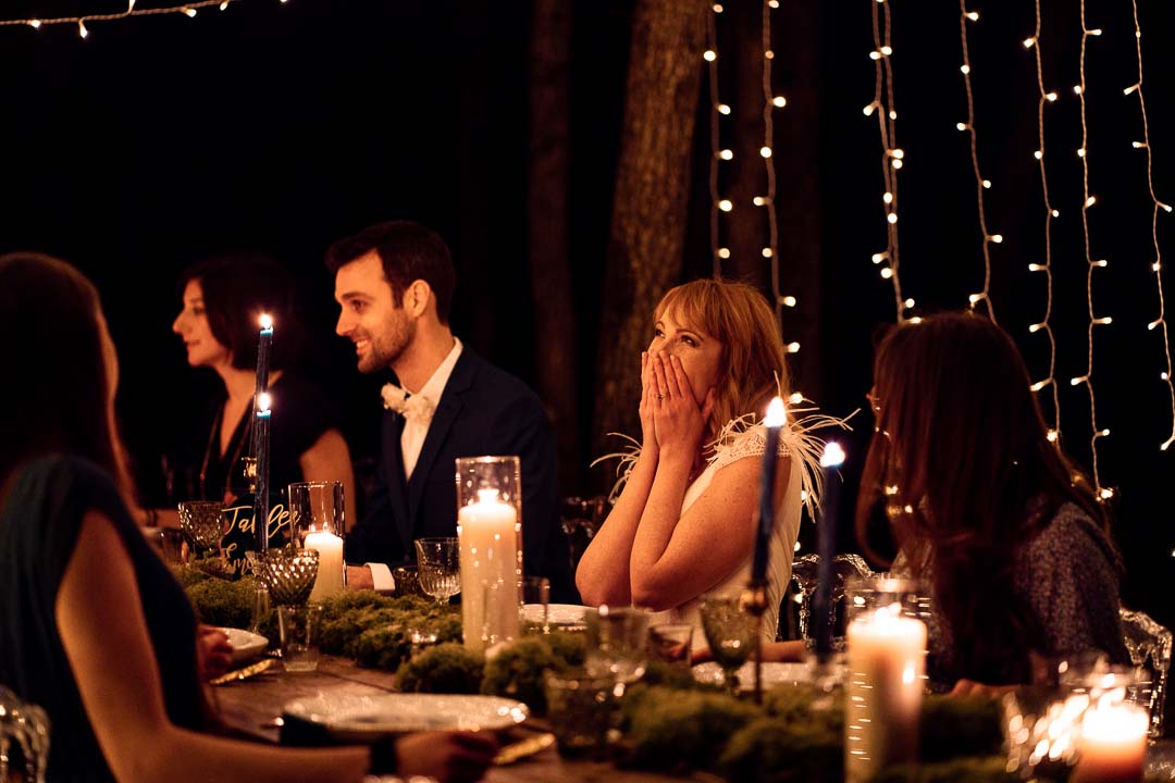 mariée émue à table, scene de nuit avec bougies