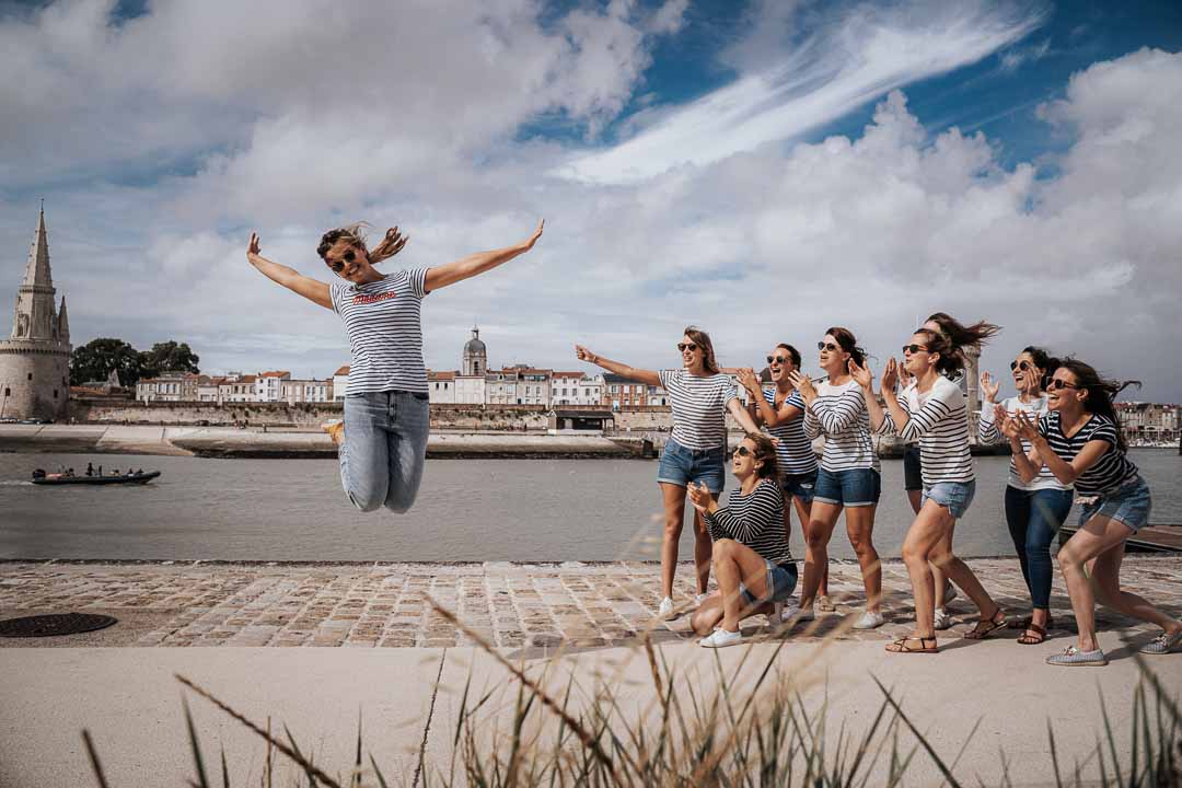 Photographe EVJF à La Rochelle, séance photo en centre ville, jean et marinieres, fille qui saute