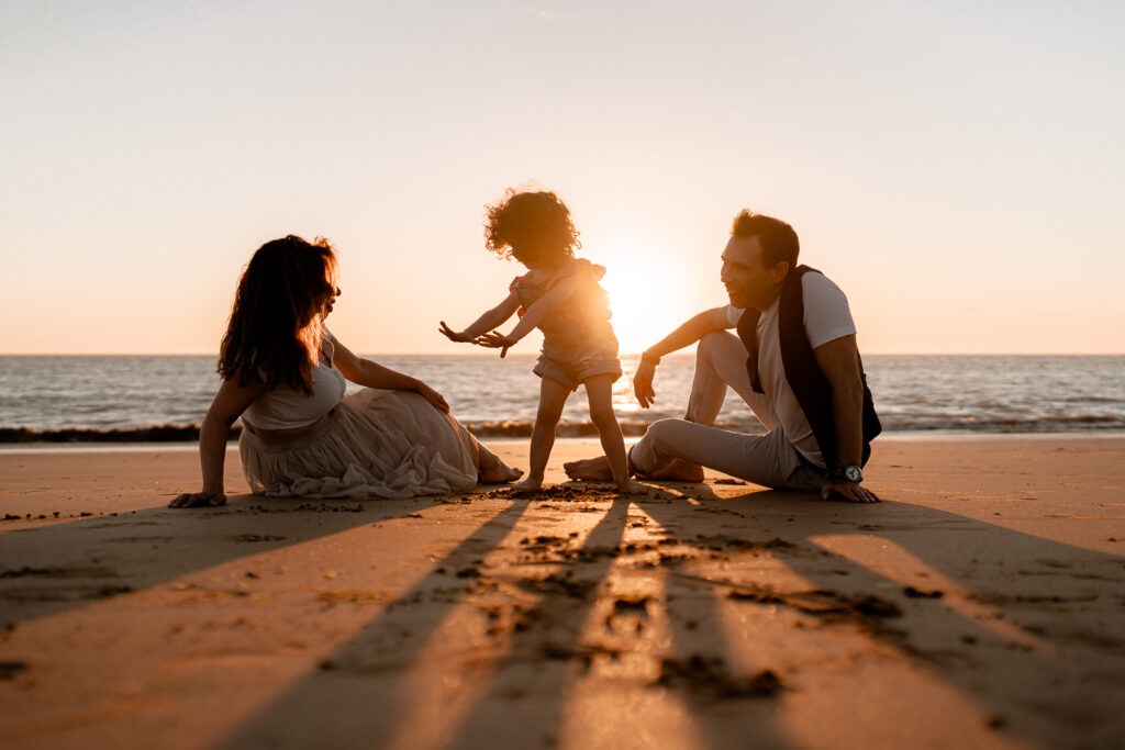 photographe famille la rochelle, séance photo au coucher du soleil sur la plage parents et enfants qui jouent dans le sable