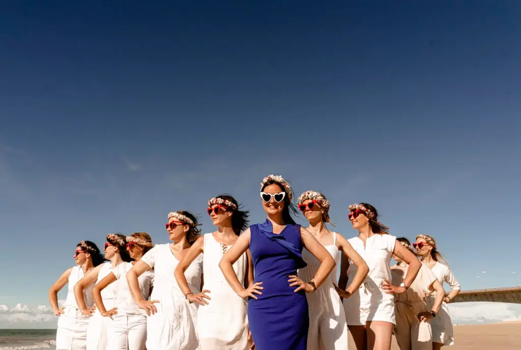 Future mariée souriante portant une robe bleue élégante sur la plage de l'Île de Ré pour sa séance photo EVJF