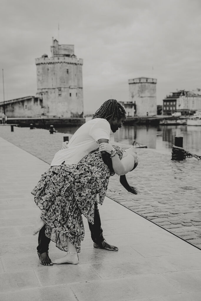 Couple en séance photo de fiançailles au Vieux-Port de La Rochelle, reflétant l'ambiance maritime