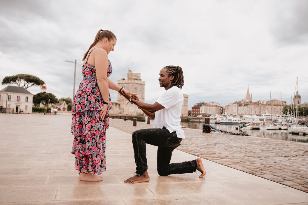 Demande en mariage pendant une séance photo à La Rochelle, devant les deux Tours