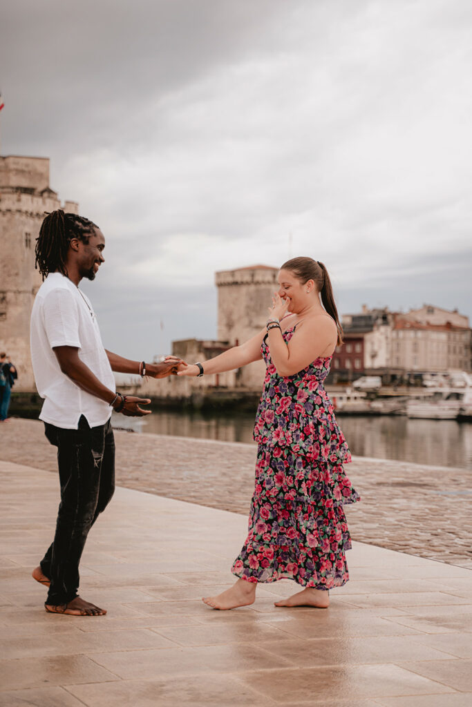 Demande en mariage pendant une séance photo à La Rochelle, devant les deux Tours