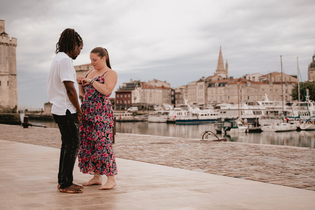 Moment joyeux pour un couple en séance photo de fiançailles dans une rue pittoresque de La Rochelle