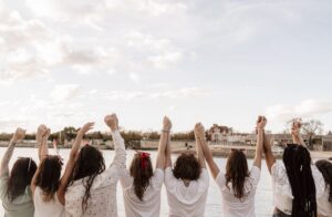 groupe de filles célébrant un EVJF, se tiennent les mains face à la ville La Rochelle