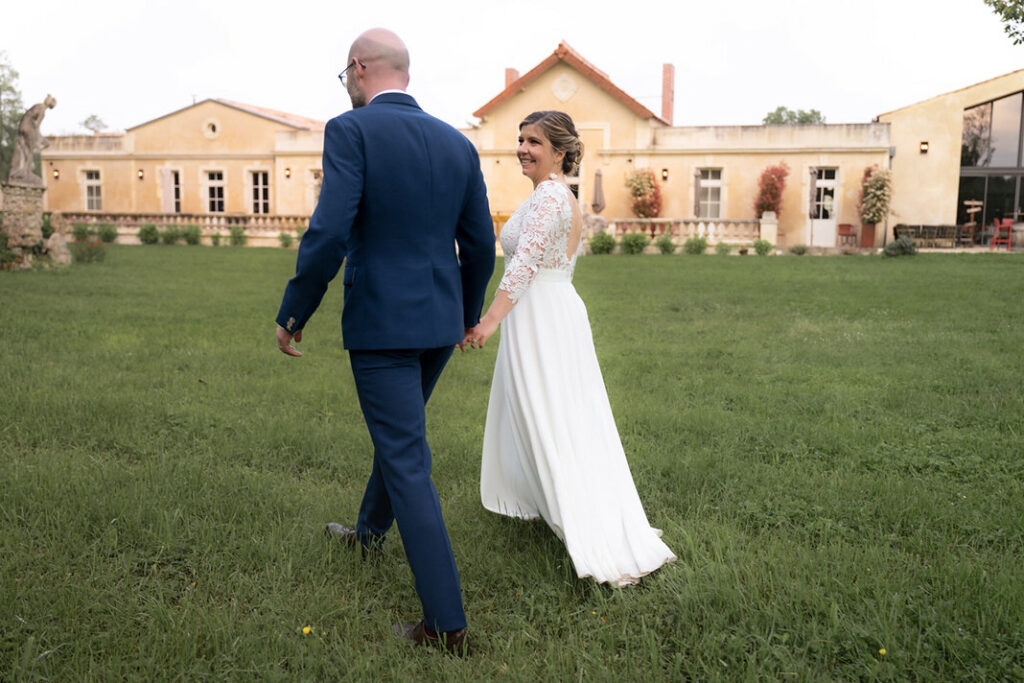 Mariage intimiste au Logis de l’Héronnière, couple souriant entouré de leurs proches dans un jardin verdoyant près de La Rochelle