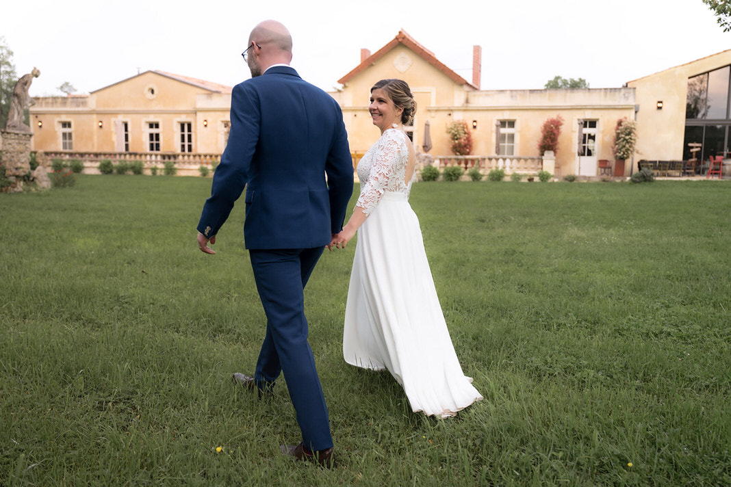 Mariage intimiste au Logis de l’Héronnière, couple souriant entouré de leurs proches dans un jardin verdoyant près de La Rochelle