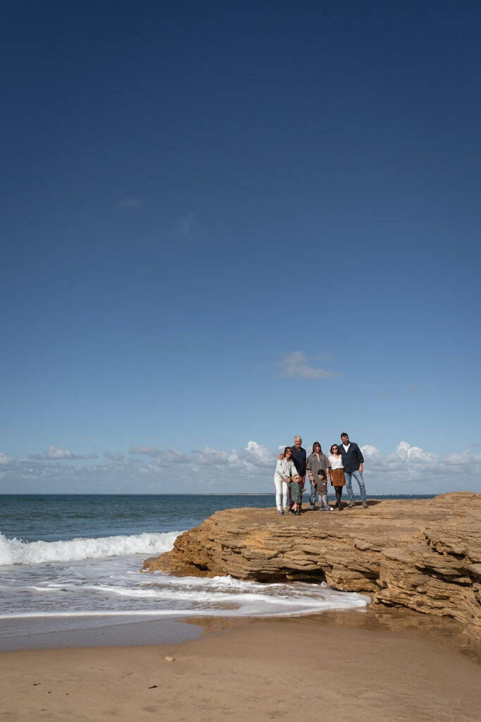 grands parents, enfants et petits enfants sur une plage secrete de l'ile de ré, ciel bleu et vagues