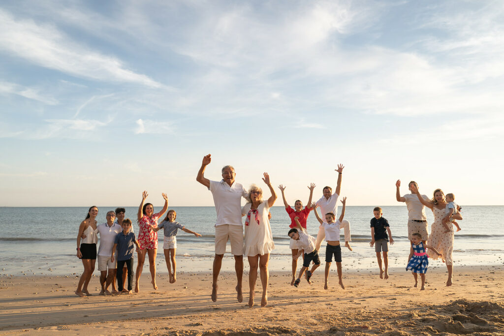 famille qui saute sur la plage, séance photo intergenerationnelle sur l'ile de ré, tenues colorées, famille heureuse