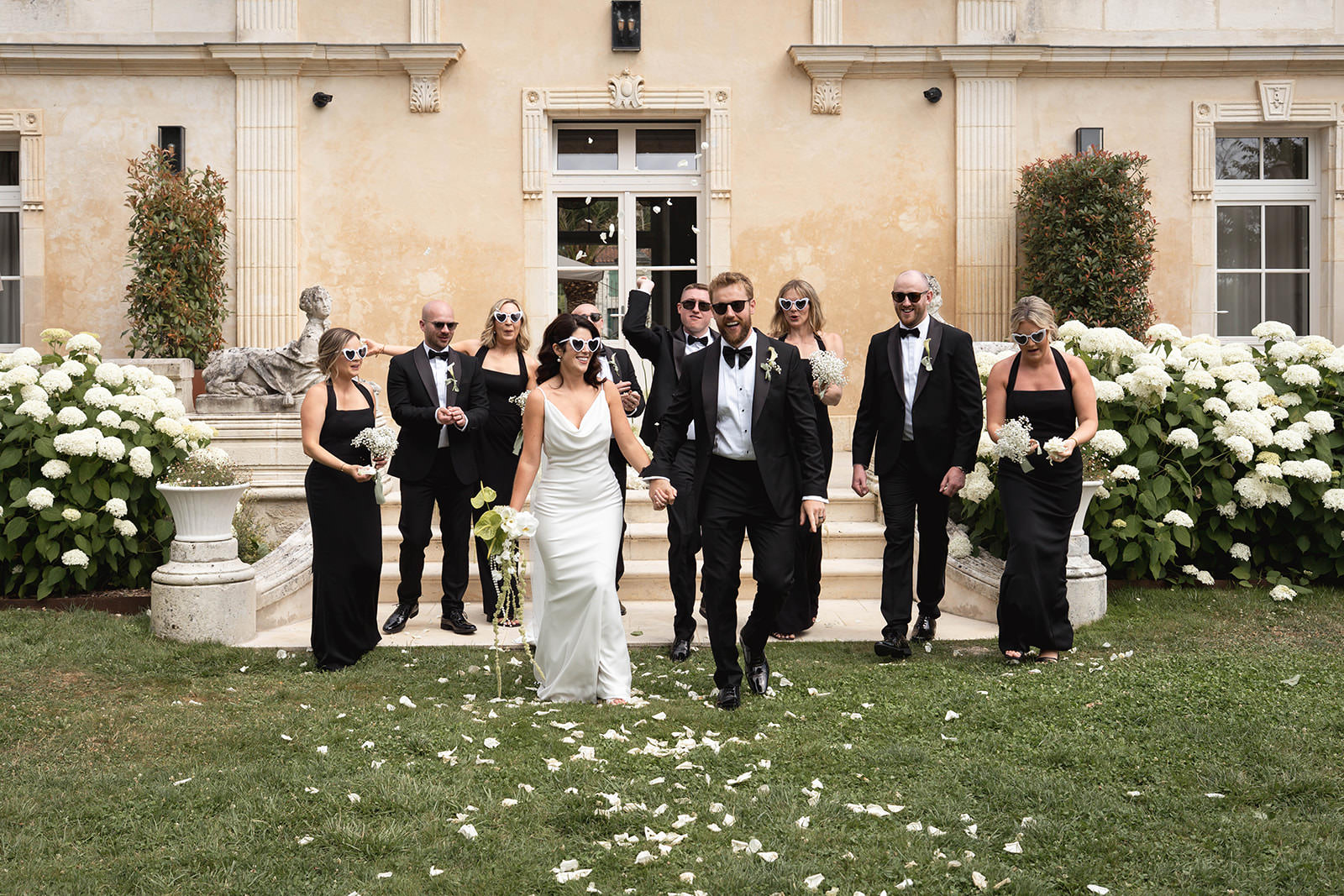 bride groom and bridal party walking on the garden, black tie wedding in France